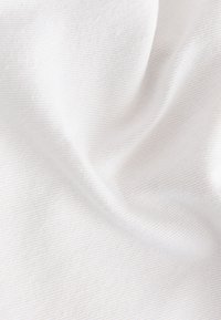 Tissu blanc doux avec une texture subtilement côtelée horizontale et des plis légers créant des ombres et des reflets.