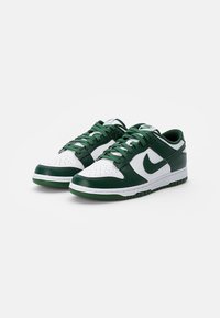 Zöld és fehér bőrből készült Nike Dunk sportcipők. Perforált orr, párnázott nyak, és vastag gumitalp, amelyen texturált tapadás található.