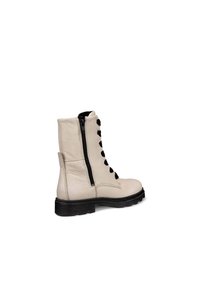 Bottines en cuir beige avec des lacets noirs, fermeture éclair latérale et semelle texturée. Dotées d'une semelle extérieure en caoutchouc noir robuste et d'une finition supérieure lisse.