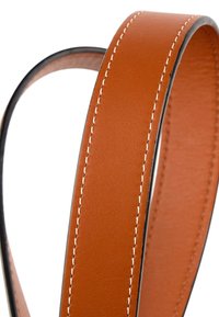 Ceinture en cuir marron avec des coutures blanches le long des bords et une doublure noire lisse sur les côtés.