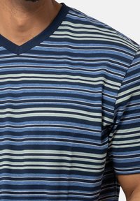 V-Ausschnitt T-Shirt mit horizontalen Streifen in Marineblau, Hellblau und Grün. Weicher Stoff mit wechselnden Stärken und glatter Textur.