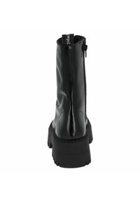 Czarne botki za kostkę wykonane z błyszczącego materiału, z bocznym zamkiem błyskawicznym i masywną podeszwą z wyraźnym bieżnikiem.