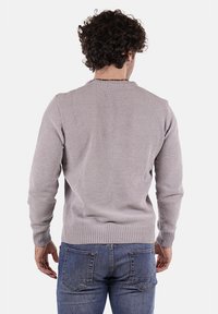 Maglione lavorato a maglia grigio chiaro con collo rotondo, polsini e orlo a costine. Presenta un motivo texture e un design a vestibilità media. Indossato sopra jeans blu.