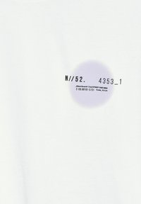 Bílá bavlněná tričko s kruhovým fialovým přechodem a černým potiskem textu, zobrazující číselné a značkové detaily.