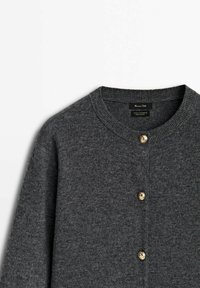 Cardigan en laine gris foncé avec un col rond, ornée de boutons dorés et d'une finition texturée, mettant en avant la douceur et la chaleur.