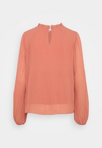 Blouse couleur pêche à manches longues, texture plissée, col haut avec une ouverture en forme de goutte d'eau à l'arrière, fabriquée en tissu léger.