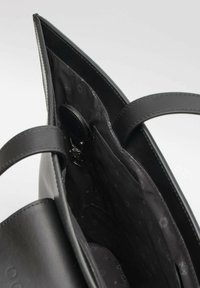 Borsa in pelle nera con due manici, apertura superiore e interno in tessuto caratterizzato da un motivo discreto. Dettagli notevoli includono una tasca interna.