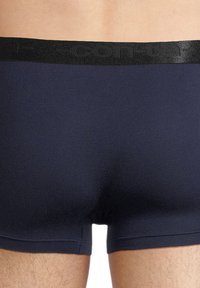Navy blue boxer briefs with a black elastic waistband featuring embossed branding, showcasing a smooth, fitted design and minimal seams.