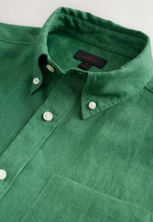 Grünes Leinenhemd mit einem Button-Down-Kragen, weißen Knöpfen und einer Brusttasche. Die Textur ist glatt mit einem leichten Glanz.