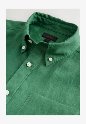 Grünes Leinenhemd mit einem Button-Down-Kragen, weißen Knöpfen und einer Brusttasche. Die Textur ist glatt mit einem leichten Glanz.