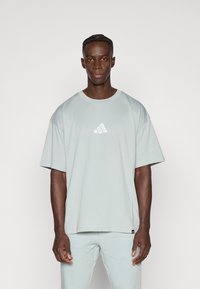 Mint πράσινο oversized t-shirt κατασκευασμένο από απαλό ύφασμα, με μικρό λευκό λογότυπο στο στήθος και κοντά μανίκια.