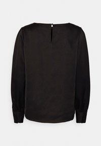 Svart blus med lång ärm, gjord av ett mjukt tyg. Har en rundad halsringning, ett nyckelhål på baksidan och knäppning vid ärmsluten.