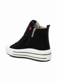 Zapatillas altas de lona negra con suela de plataforma blanca, que presentan un cierre lateral, cordones negros y un acento naranja cerca de los ojales.