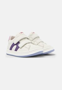 Baskets blanches avec un accent de design violet, deux sangles Velcro et une semelle en caoutchouc. Matière supérieure texturée avec un détail de talon rose.
