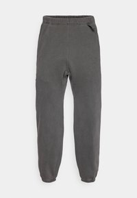 Gray sweatpants with an elastic waistband, tapered legs, and stitching details. Made from soft fabric with a smooth texture.