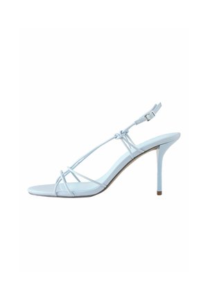 Balti aukštakulniai sandalai su plonais kulkšnies dirželiais su sagtimi ir smailia kulne, pateikti šonu ant balto fono.