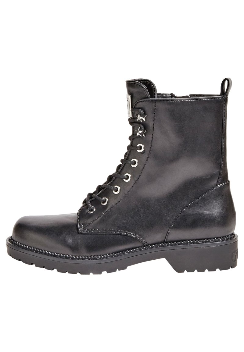 Bottines en cuir noir avec un nez rond, cuir à lacets sur le devant, œillets en métal et accents en forme d'étoile. Surface texturée et semelle épaisse.
