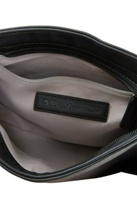 Schwarze Handtasche mit Reißverschluss innen, die mit einem glatten Textilin dieser Auskleidung, einem Lederetikett mit "DENIM TOM TAILOR" und einem dezenten Glanz ausgestattet ist.