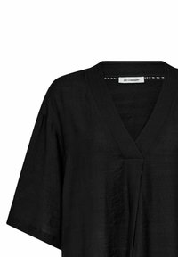 Top negru din in, cu decolteu în V, mâneci scurte și lejere, și un material texturat. Eticheta: co'couture.