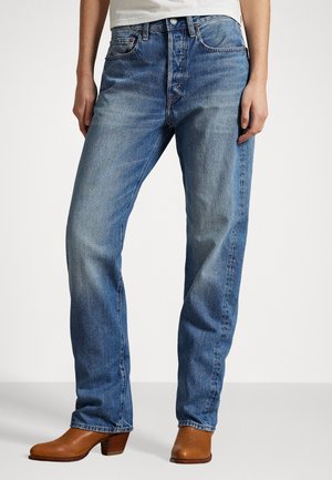 Lichtblauwe spijkerbroek met een recht model, voorzien van vijf zakken, een knoopsluiting aan de voorkant en casual bruine leren laarzen.