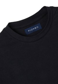 Camiseta de algodón navy con escote redondo y etiqueta PIOMBO en el cuello. Presenta una textura suave y un diseño clásico y sencillo.