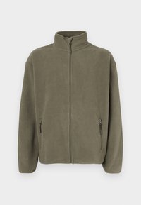 Μπουφάν φλις ελιάς με πλήρες φερμουάρ μπροστά, ψηλό γιακά, μακριά μανίκια και δύο πλαϊνές τσέπες με φερμουάρ.