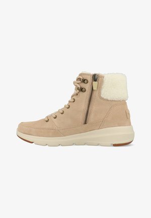 Beige suede ankle boot with side zipper, lace-up front, cushioned sole, and white fleece collar for warmth and comfort.