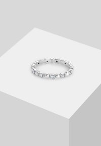 Inel din argint cu accente alternante de zirconiu cubic rotund și pătrat. Finisaj neted, banda are un design interconectat și este lustruită.