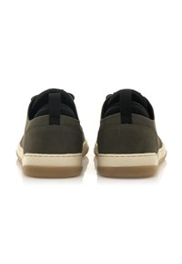 Zapatillas de deporte verde oscuro con una textura lisa, suelas de goma blanca y lengüetas en la parte trasera. Diseño sencillo con acentos mínimos.