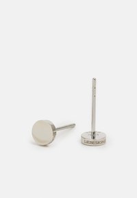 Orecchini a perno in tonalità argento con design a disco piatto circolare, caratterizzati da una finitura lucida e dettaglio del logo inciso sul retro.