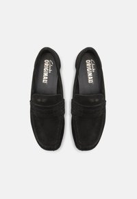 Sorte semsket loafers med rund tå, sydde detaljer og polstret overdel. Innvendig har de "Clarks Originals" merkevare på en grå såle.