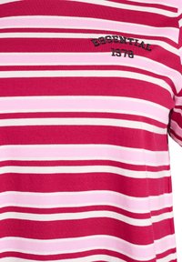 Punaste ja roosade triipudega puuvillasest materjalist T-särk, millel on lühikesed varrukad ja musta värviga tikitud "ESSENTIAL 1978" detail.