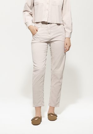 Light pink cropped button-up shirt with a frayed hem, paired with light beige straight-leg pants and brown slip-on shoes with accents.