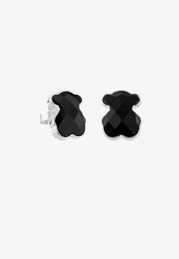 Pendientes en forma de oso negro con un diseño facetado, fabricados en metal con acabado plateado. Cuentan con un respaldo transparente para un ajuste seguro.