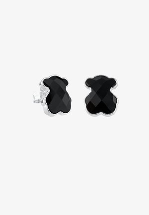 Orecchini a forma di orso nero con design sfaccettato, in metallo di tonalità argentata. Presentano uno sfondo trasparente per una calzata sicura.