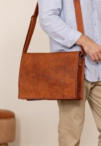 Borsa a messaggero in pelle marrone con finitura liscia, forma rettangolare, tracolla regolabile e dettagli di cucitura a contrasto.
