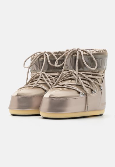Beige waterproof boots with a glossy finish, textured lace-up design, padded top, and rubber sole for traction.