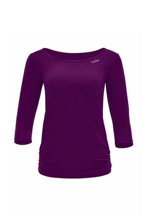 Bluza mov pentru femei cu mâneci lungi, cu părți adunate și decolteu larg, având un text mic alb "Windshape" lângă guler.