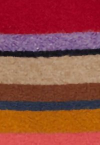 Campioni di tessuto impilati in strisce orizzontali di rosso, viola, beige, marrone, blu navy, giallo e rosa; texture morbida con un aspetto lanuginoso.