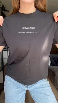 Černé bavlněné tričko s bílým logem "Calvin Klein" přes hruď. Krátké rukávy, kulatý výstřih, uvolněný střih.