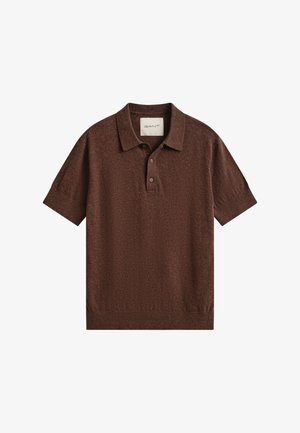 Polo en maille marron à manches courtes avec col, patte à deux boutons, poignets et ourlet côtelés, étiqueté GANT à l’intérieur du col.