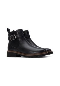 Botines de cuero negro con paneles laterales elásticos, punteras cuadradas y una hebilla decorativa. Suelas de goma con un ligero tacón y detalles de costura.
