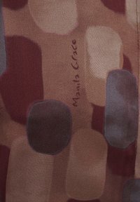 Tessuto di seta con forme astratte in color bordeaux, beige e blu. Include la scritta "Manila Grace" stampata in un design sottile. Texture liscia.