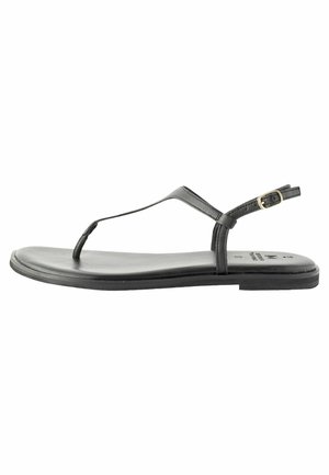 Sandalo piatto nero con cinturini sottili, design con punto per le dita e fibbia alla caviglia. La suola è liscia con un profilo minimalista.