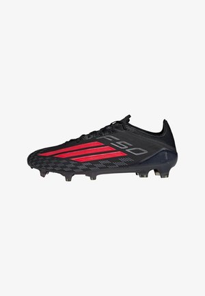 Chaussure de football noire et rouge avec crampons, design bas, lacets et dessus texturé, vue de côté.