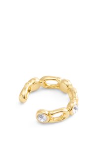 Ring i guldton med sammanlänkade ovala och rundade former, prydd med två klara ädelstenar och en slät, polerad yta.