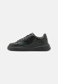 Sneaker in pelle nera con finitura lucida, dotate di un pannello testurizzato, lacci piatti e una suola nera spessa. Logo impresso di lato.