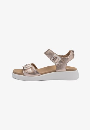 Metallic rose gold sandals with two adjustable straps, flat cushioned footbed, and thick white outsole. Features a smooth texture.