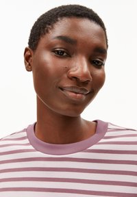 Gestreifter Pullover an einem Modell; verfügt über lila und weiße Streifen, einen runden Halsausschnitt, kurze Ärmel und eine weiche, glatte Textur.