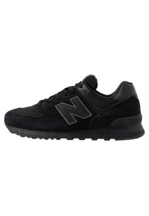 Sort New Balance sneaker med ruskind og mesh overdel, snørelukning og tekstureret sål, set fra siden på en hvid baggrund.